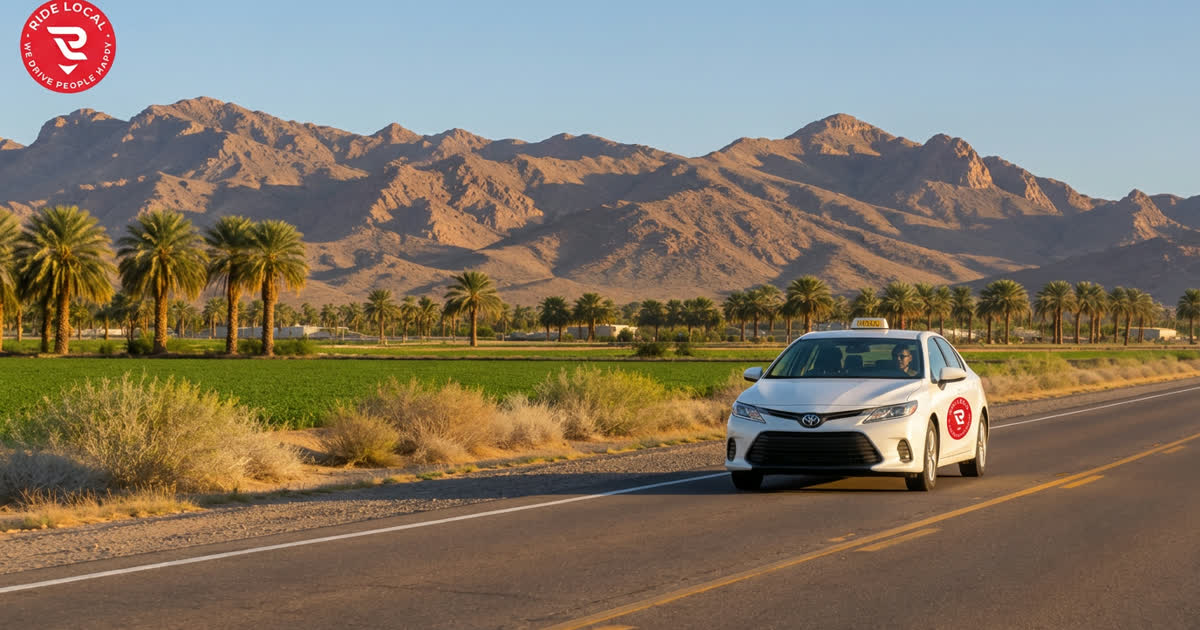 Ride Local taxi with the Ride Local logo on its door, driving the highway near Wellton, Arizona past palm trees, farm fields and the Gila Mountains